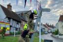 Nevertheless, bunting is continuing to go up in areas of Suffolk. Pictured: Fire crews helping put up bunting in Debenham.
