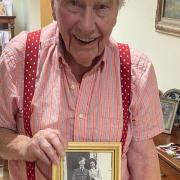 Bernard Hood with a framed photo of himself with his wife Joy