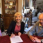 Gareth Cole (trustee), Shirley Moore (chair of Hive) sign the contract to buy the church with John Smith as a witness